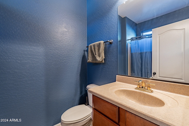 bathroom with a shower with curtain, vanity, and toilet