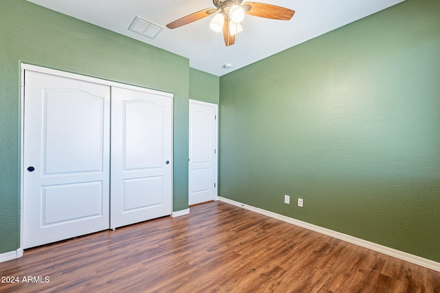 unfurnished bedroom featuring ceiling fan, dark hardwood / wood-style floors, and a closet