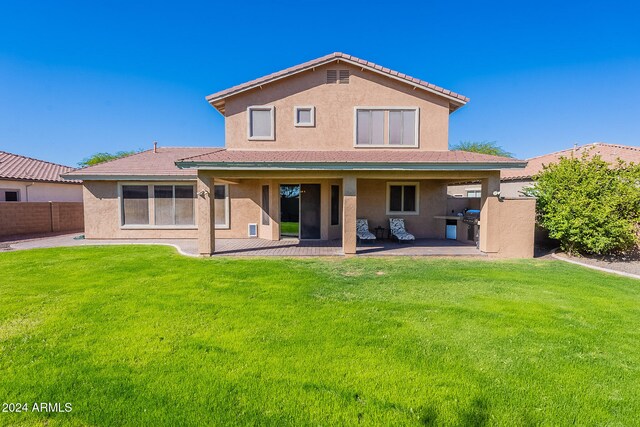 back of house featuring a patio and a yard