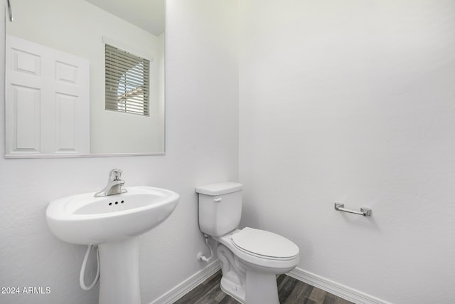 bathroom with hardwood / wood-style floors, toilet, and sink