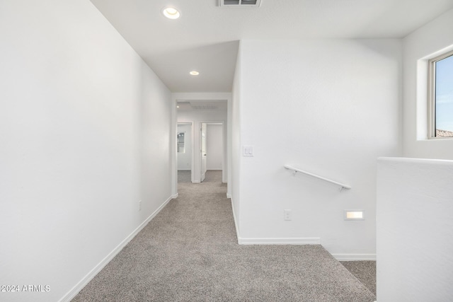 corridor featuring light colored carpet