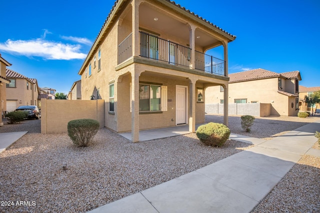 view of front of property featuring a patio area and a balcony