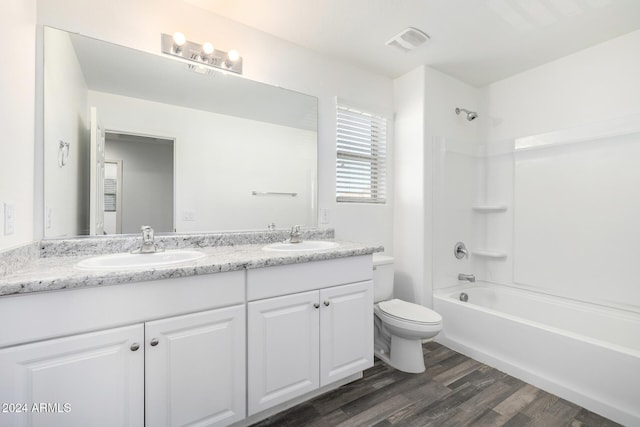 full bathroom with hardwood / wood-style flooring, vanity, shower / bathtub combination, and toilet