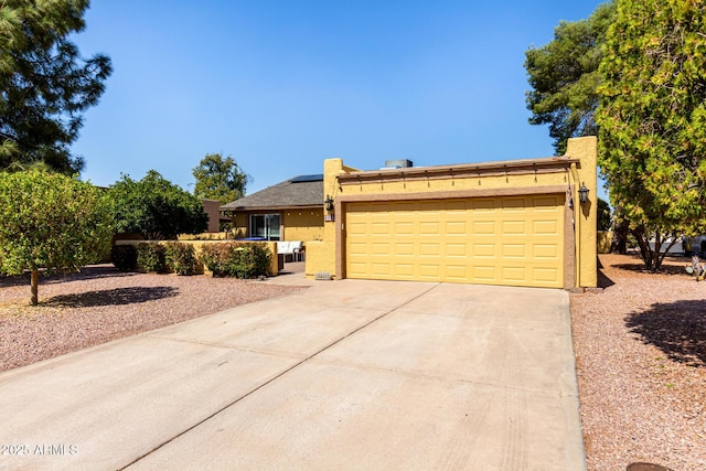 ranch-style house featuring a garage, solar panels, concrete driveway, and stucco siding