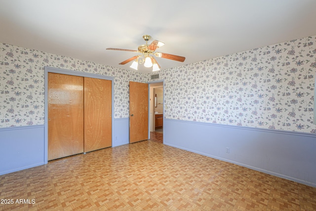 5228 E Des Moines St, Mesa, AZ 85205 - unfurnished bedroom featuring wallpapered walls, wainscoting, a closet, a ceiling fan, and baseboards