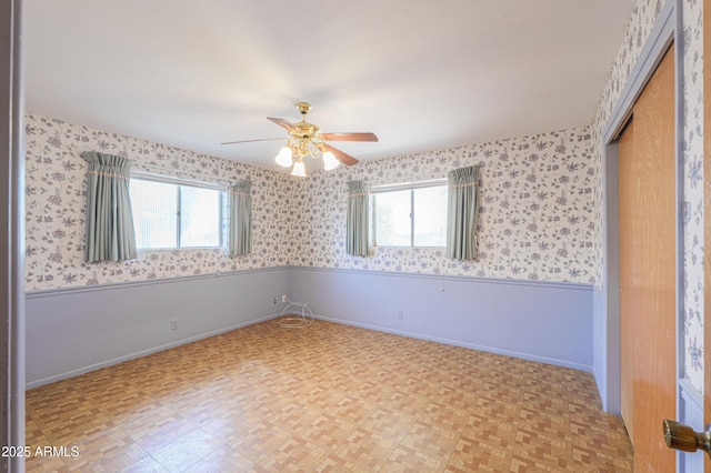 5228 E Des Moines St, Mesa, AZ 85205 - spare room with healthy amount of natural light, a ceiling fan, a wainscoted wall, baseboards, and wallpapered walls