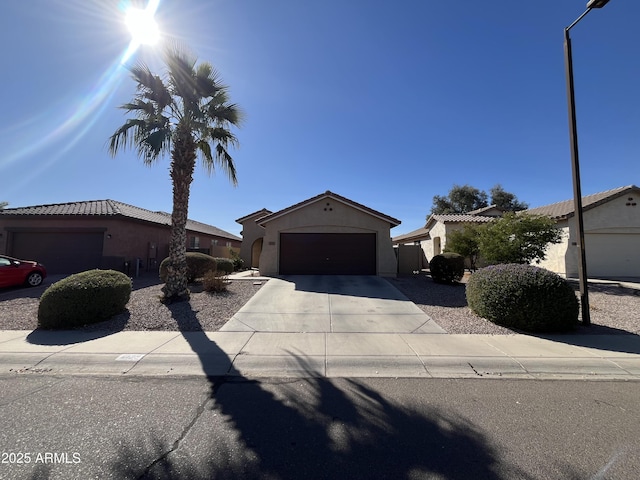 view of front of home featuring driveway, an attached garage, and stucco siding