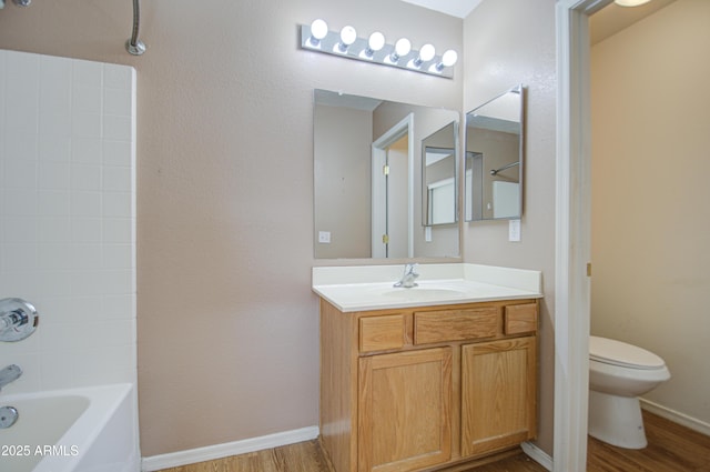 bathroom with baseboards, vanity, toilet, and wood finished floors