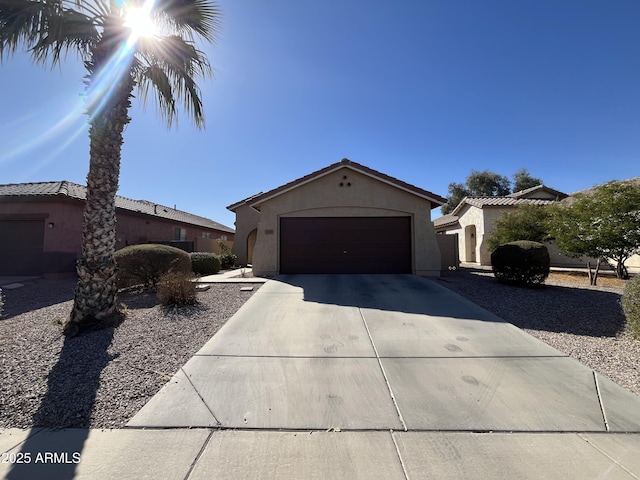 view of front of house featuring concrete driveway, an attached garage, and stucco siding