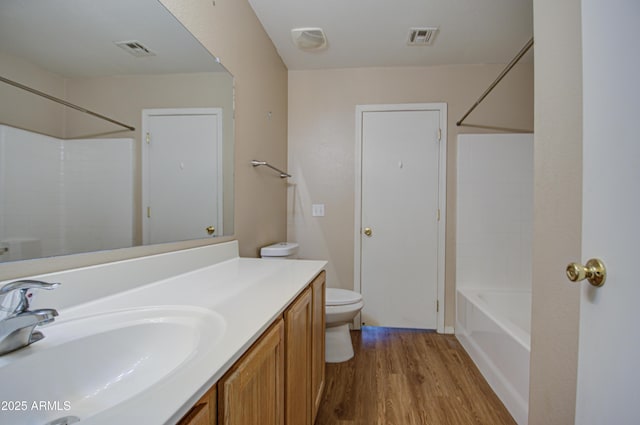 full bathroom featuring toilet, vanity, wood finished floors, and visible vents