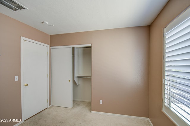 unfurnished bedroom featuring a closet, visible vents, baseboards, and carpet flooring