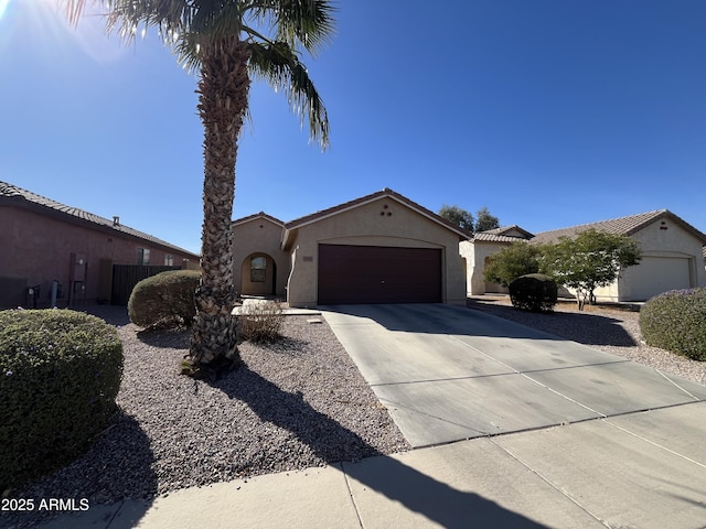 view of front of home featuring driveway, an attached garage, and stucco siding