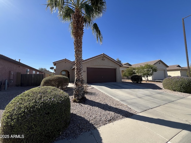 view of front of home with a garage, driveway, fence, and stucco siding