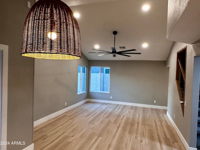 unfurnished room featuring light hardwood / wood-style floors, ceiling fan, and vaulted ceiling