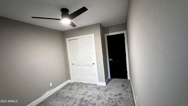 unfurnished bedroom featuring ceiling fan, a closet, and light carpet