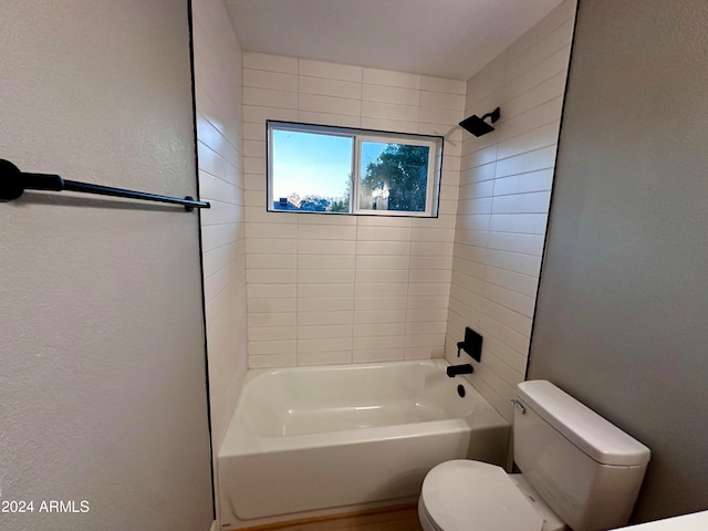 bathroom with tiled shower / bath and toilet