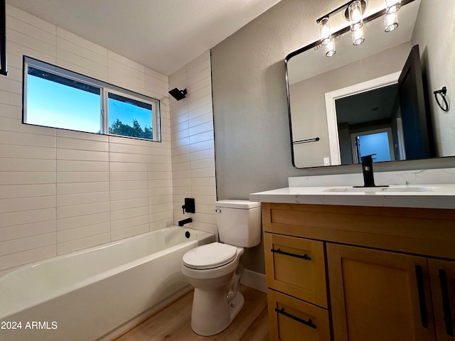 full bathroom featuring tiled shower / bath combo, vanity, toilet, and hardwood / wood-style floors