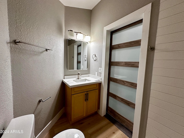 bathroom featuring hardwood / wood-style floors, vanity, and toilet