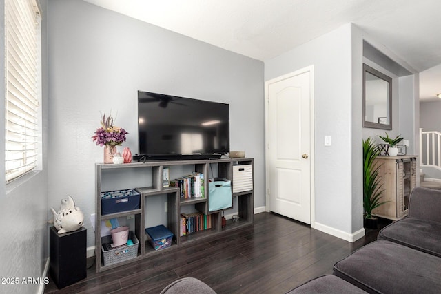 living area with baseboards and wood finished floors