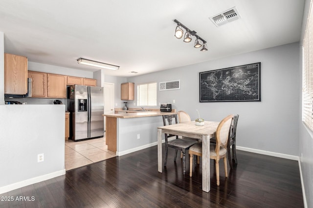 dining space featuring visible vents, light wood-style flooring, rail lighting, and baseboards