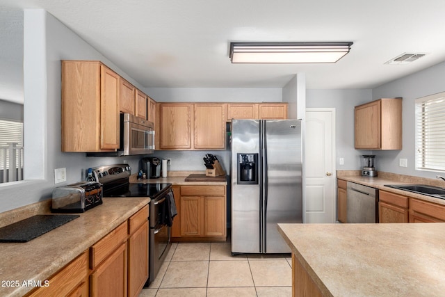 kitchen with visible vents, appliances with stainless steel finishes, light tile patterned flooring, and light countertops