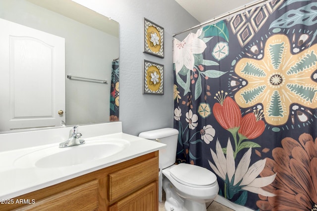 bathroom featuring toilet, vanity, and a shower with curtain