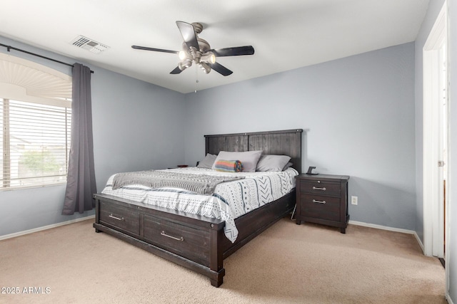 bedroom with baseboards, visible vents, and light carpet