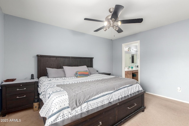 bedroom featuring light carpet, connected bathroom, a ceiling fan, and baseboards