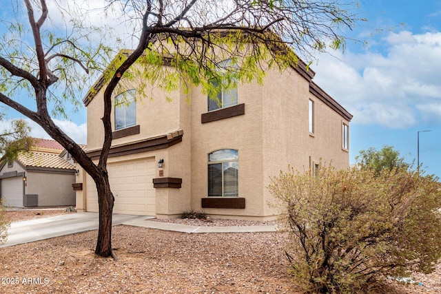 view of side of home featuring stucco siding, concrete driveway, and an attached garage