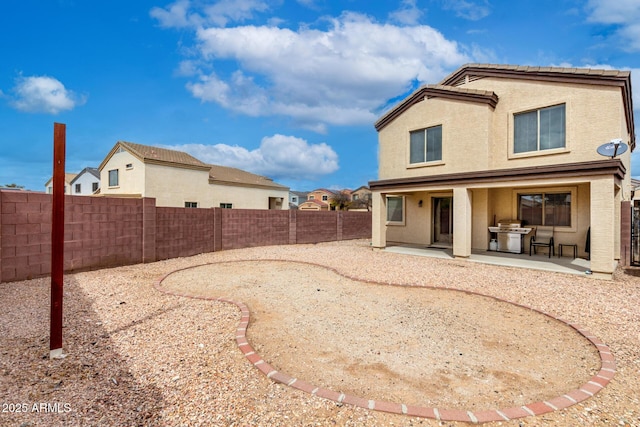 back of property with stucco siding, a patio, and a fenced backyard