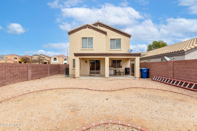 back of property featuring a fenced backyard, stucco siding, and a patio