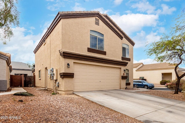 view of front facade featuring stucco siding, driveway, an attached garage, and fence