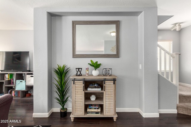 hall featuring baseboards and wood finished floors