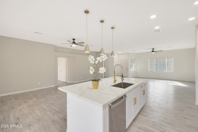 kitchen featuring sink, white cabinets, hanging light fixtures, stainless steel dishwasher, and a center island with sink