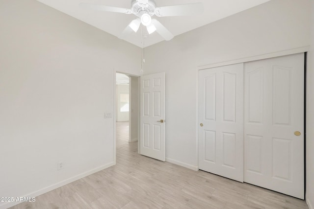 unfurnished bedroom with ceiling fan, light wood-type flooring, and a closet