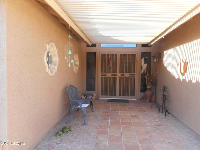 view of exterior entry with a patio area