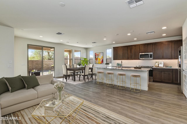 living room with sink and light hardwood / wood-style flooring