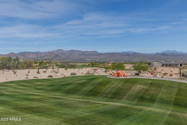 view of community featuring a lawn, a patio area, and a mountain view