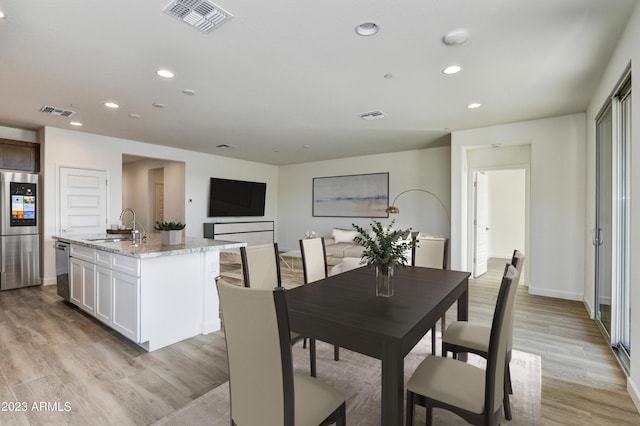 dining room with light hardwood / wood-style floors and sink