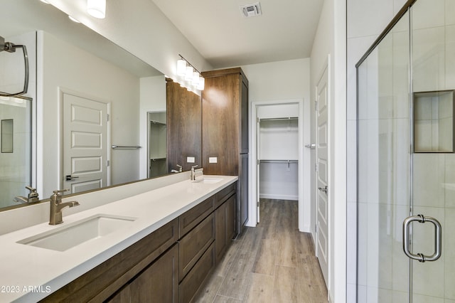 bathroom featuring vanity, wood-type flooring, and an enclosed shower