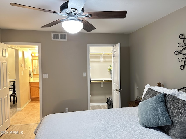 bedroom featuring a walk in closet, ceiling fan, and a closet