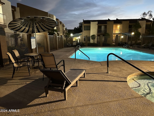 pool at dusk featuring a patio area