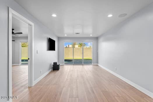 unfurnished living room featuring plenty of natural light, light hardwood / wood-style flooring, and ceiling fan