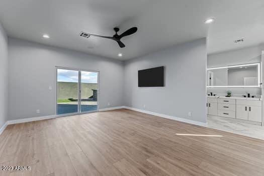 unfurnished living room featuring ceiling fan, sink, and light hardwood / wood-style flooring