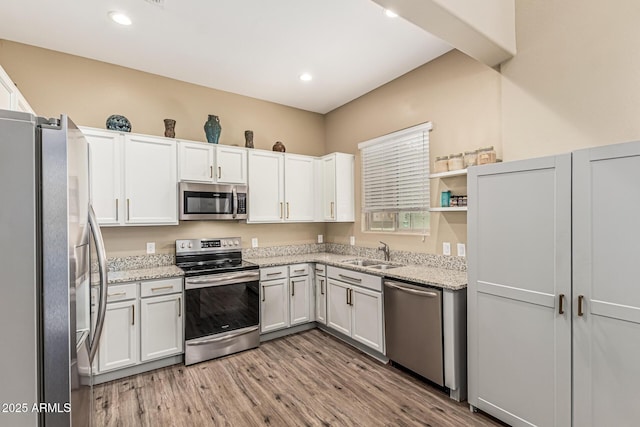 1367 S Country Club Dr Unit 1331, Mesa, AZ 85210 - kitchen with stainless steel appliances, light wood finished floors, white cabinetry, light stone countertops, and open shelves