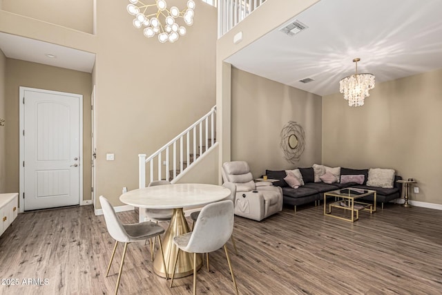 1367 S Country Club Dr Unit 1331, Mesa, AZ 85210 - dining space featuring a chandelier, stairway, wood finished floors, and a high ceiling