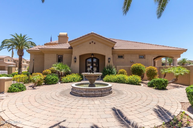 1367 S Country Club Dr Unit 1331, Mesa, AZ 85210 - view of front of house featuring stucco siding, a tiled roof, french doors, and a chimney