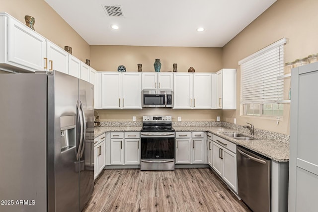 1367 S Country Club Dr Unit 1331, Mesa, AZ 85210 - kitchen with stainless steel appliances, light wood-type flooring, white cabinetry, and recessed lighting