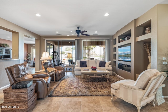 living room featuring built in shelves, ceiling fan, and light tile patterned flooring