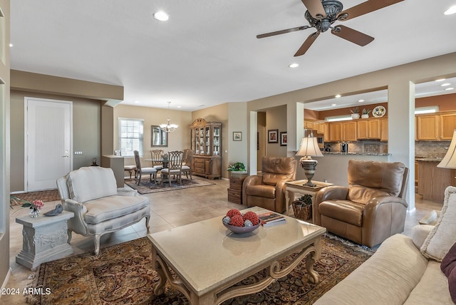 tiled living room featuring ceiling fan with notable chandelier